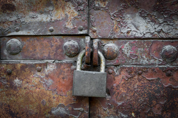 Privacy concept background: old rusty metal door closed with a massive lock