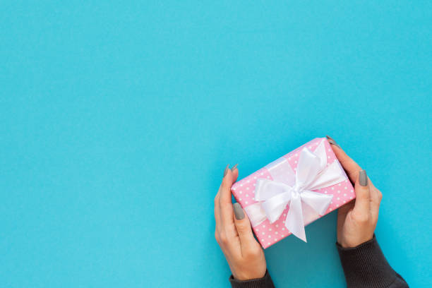 istock Background with female hands holding a gift box 1193267753