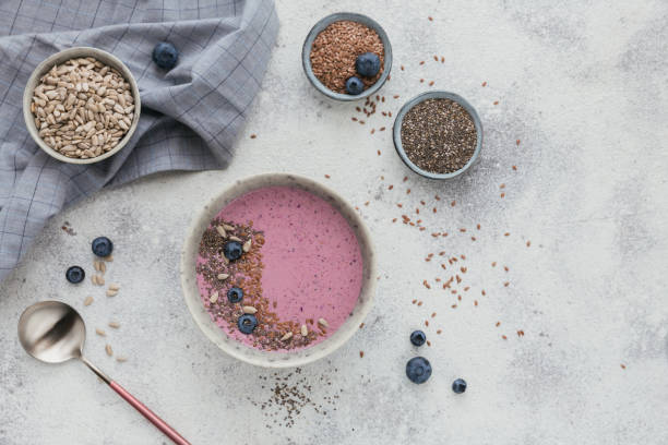 pink yogurt smoothie bowl made with fresh blueberry and seeds - vitality food food and drink berry fruit imagens e fotografias de stock
