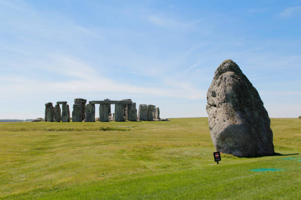View of Stonehenge with green meadow and blue sky on a sunny day in Spring, United Kingdom