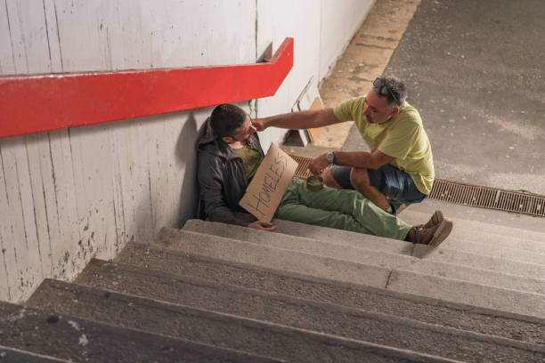 Homeless Beggar is Receiving Money from a Kind Man Lonely and Desperate Man is Sitting on the Ground in the Street and Asking for Help. An Honest and Kind Person is Approaching him and Giving him Money. transparent donation box stock pictures, royalty-free photos & images