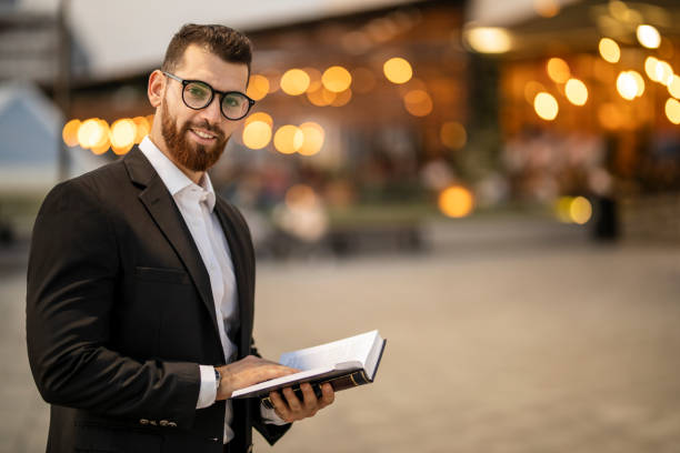 istock Businessman reading a book in public park 1193270260