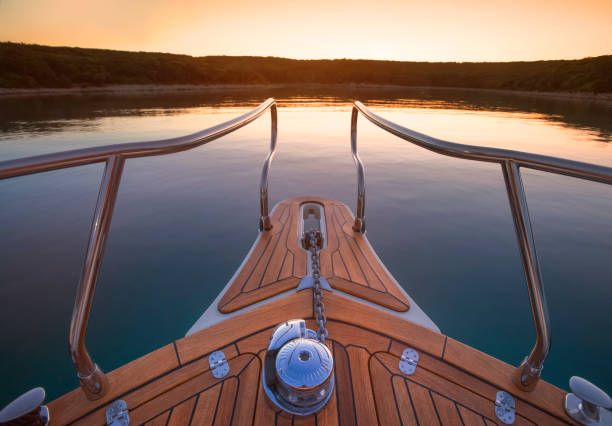 Deck of luxury yacht moored in sea during sunset.