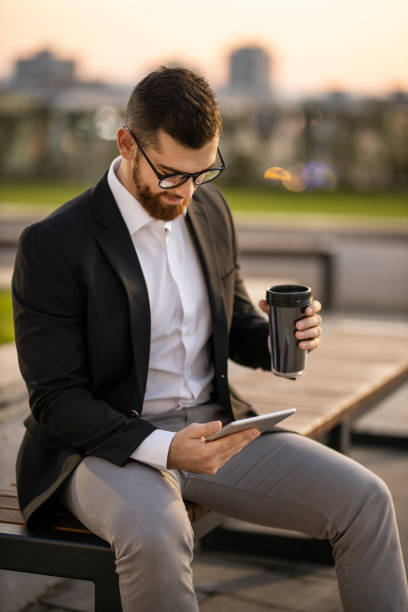 istock Businessman drinking coffee and working on digital tablet 1193272192