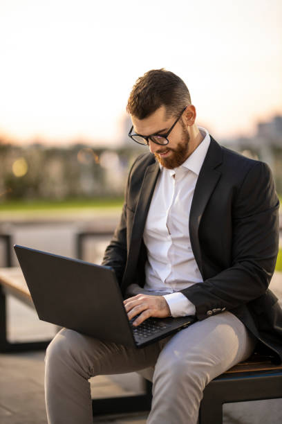 istock Businessman working on laptop in public park 1193272472