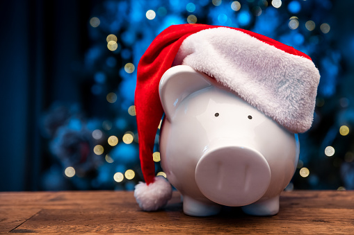 Piggy bank with Santa hat on Christmas background