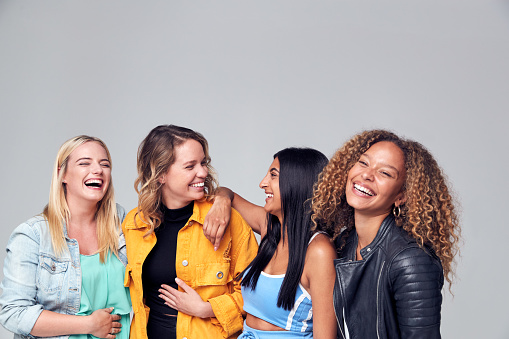 Retrato de estudio de grupo de amigos femeninos multiculturales sonriendo a la cámara juntos photo