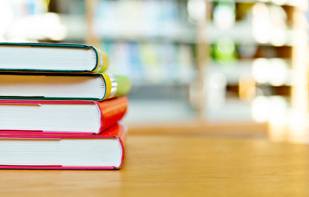 Stack of books on the table of public library.