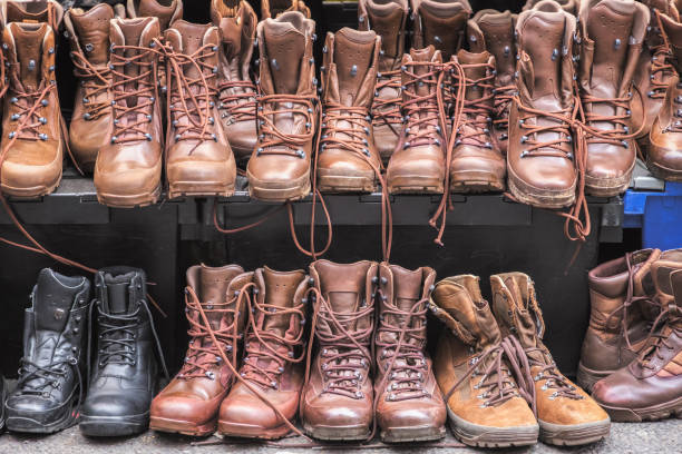 подержанные боевые коричневые сапоги на брик лейн воскресенье рынке в лондоне - military boots стоковые фото и изображения