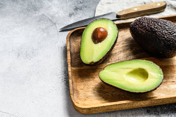 istock Avocado halves on a wooden cutting Board. Gray background. Top view. Space for text 1193275232