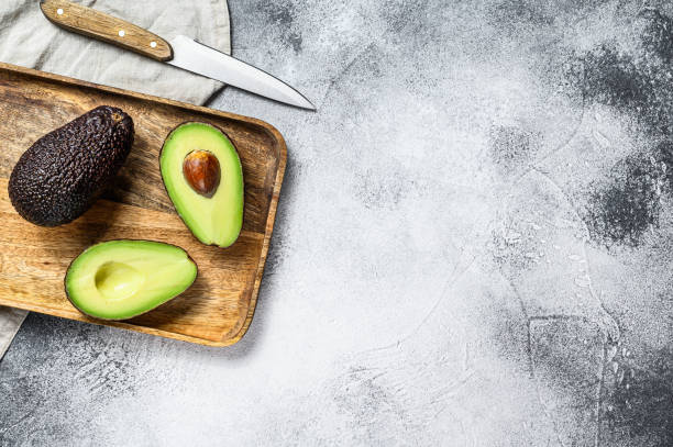 istock Avocado halves on a wooden cutting Board. Gray background. Top view. Space for text 1193275250