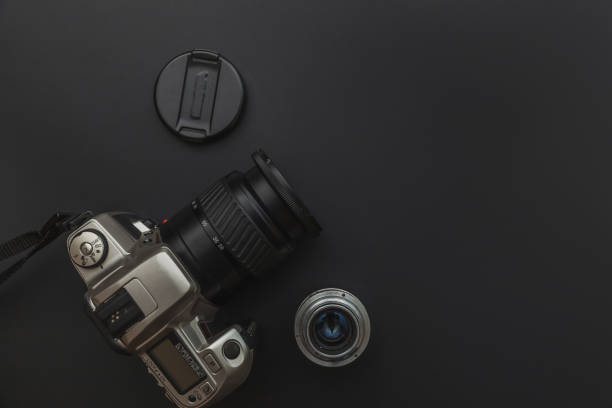 istock Photographer workplace with dslr camera system and lens on dark black table background. Hobby travel photography concept. Flat lay top view copy space 1193276165