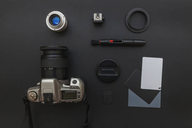 istock Photographer workplace with dslr camera system, camera cleaning kit, lens and camera accessory on dark black table background. Hobby travel photography concept Flat lay top view copy space 1193276176