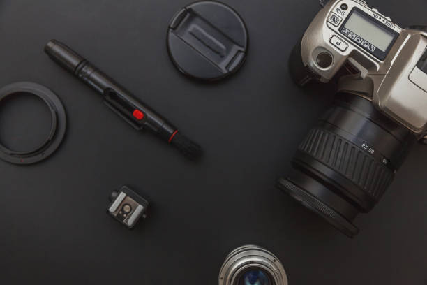 istock Photographer workplace with dslr camera system, camera cleaning kit, lens and camera accessory on dark black table background. Hobby travel photography concept Flat lay top view copy space 1193276191