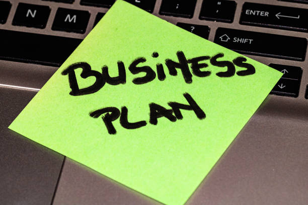 istock Writing on colorful sticky note Business plan. Business plan on paper. Sticky note, post it on keyboard. 1193278068