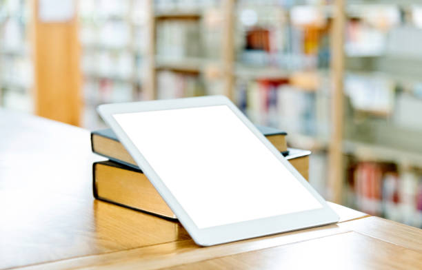 istock Digital tablet and books on the table of public library 1193278100