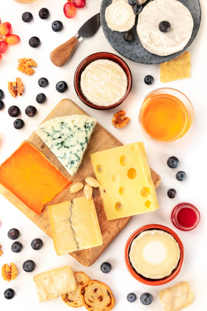istock Cheese board, a flat lay overhead shot on a white background. Blue cheese, red Leicester, Emmental, goat cheese, Brie and others with wine, fruits, nuts and almonds 1193279195