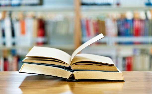istock Two open book on the table of public library 1193279403