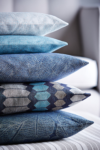 Shot of multi-colored pillows stack on ottoman stool