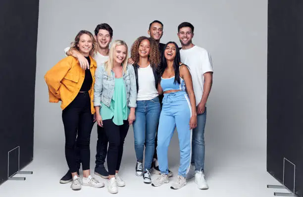 Group Studio Photo Shoot Of Young Multi-Cultural Friends Smiling And Laughing At Camera