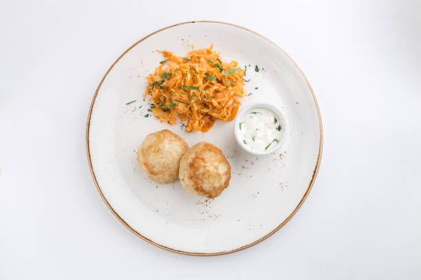 meat balls and cabbage stew with white sauce isolated on white background top view