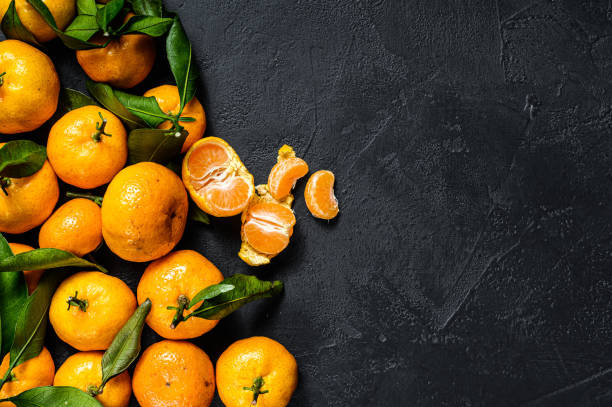 istock Tangerines, mandarines  with leaves. Black background. Top view. Space for text 1193282107