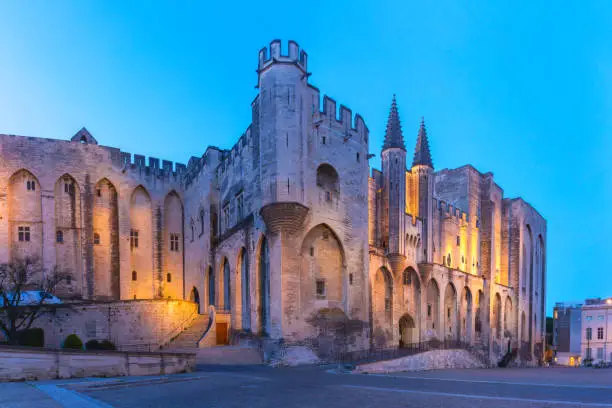 Medieval Gothic buildings in Avignon during evening blue hour, southern France