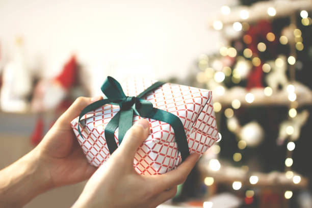 istock Man's hands holding and giving Christmas present 1193287641
