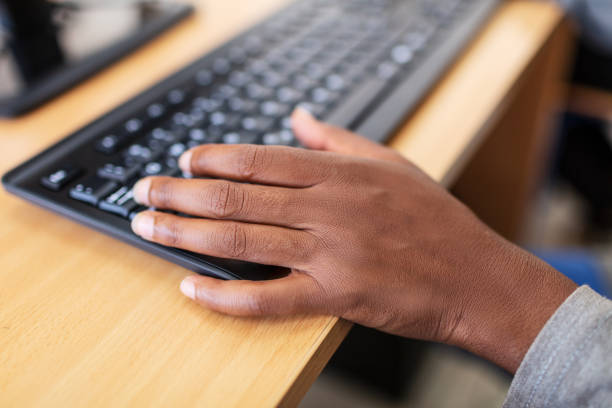 istock African man hands on black keyboard and wood table. 1193287710