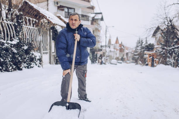 istock Older man clearing snow in the street 1193289075