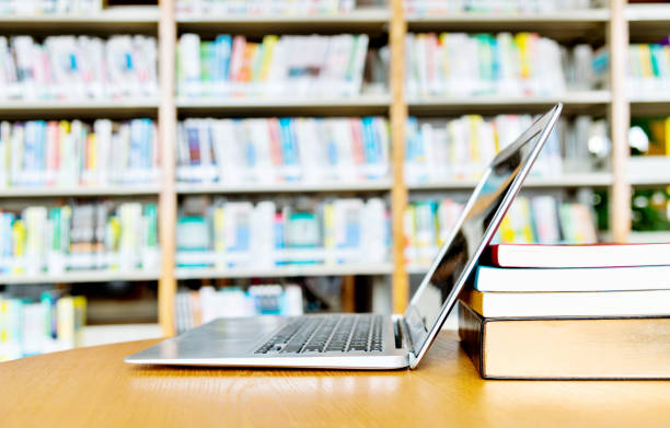 istock Blank laptop and books on the table of library 1193289967