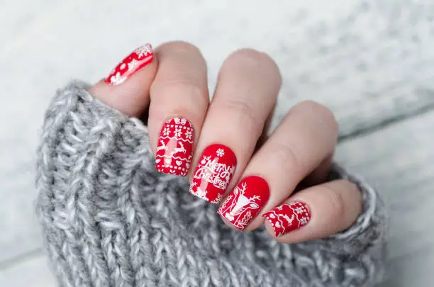 Photo of red Christmas manicure with deer and snowflakes