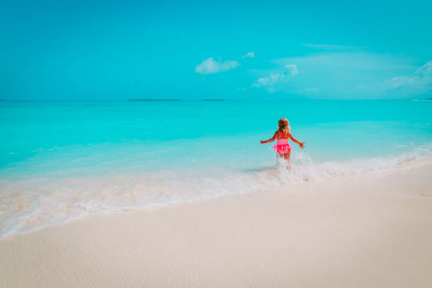 istock little girl run play with waves on the beach 1193290227