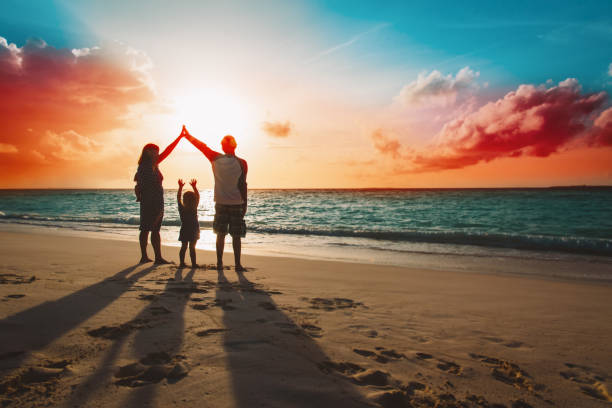 子供たちと幸せな家族は夕焼けのビーチで遊ぶ - beach mother family playful ストックフォトと画像