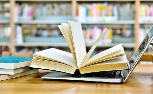istock Open book on the laptop keyboard 1193290269