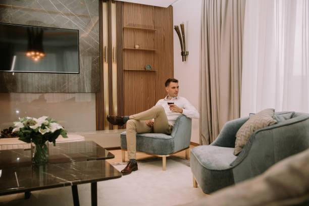 istock Young man sits in a luxury apartment, drinking red wine and and relaxing 1193292071