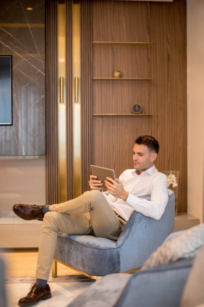 istock Handsome young man using digital tablet at luxury apartment 1193292988