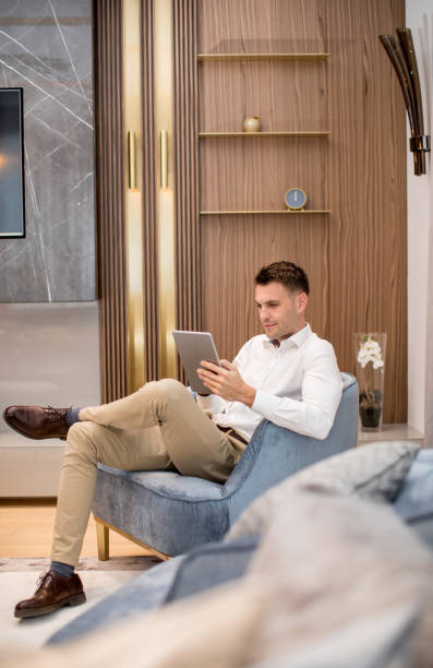 istock Handsome young man using digital tablet at luxury apartment 1193293202
