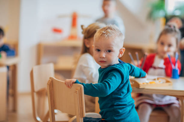 istock Cute boy with friends in preschool classroom 1193293675