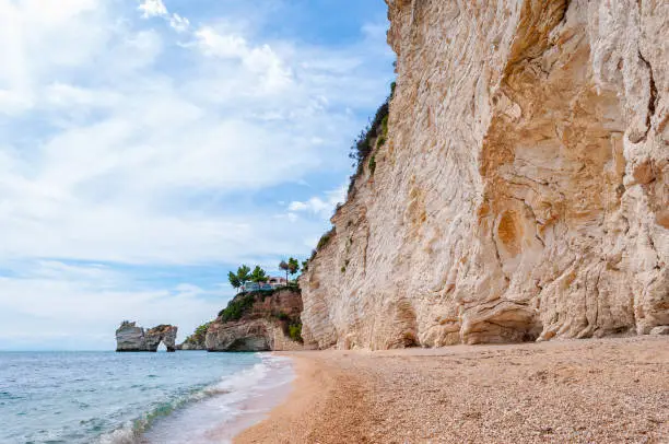 Famous sea stacks of Baia delle Zagare bay in Gargano National park. Natural rock sculptures made by Adriatic sea waves, wind and erosion stacked in the sea near the rocky beach of Baia delle Zagare
