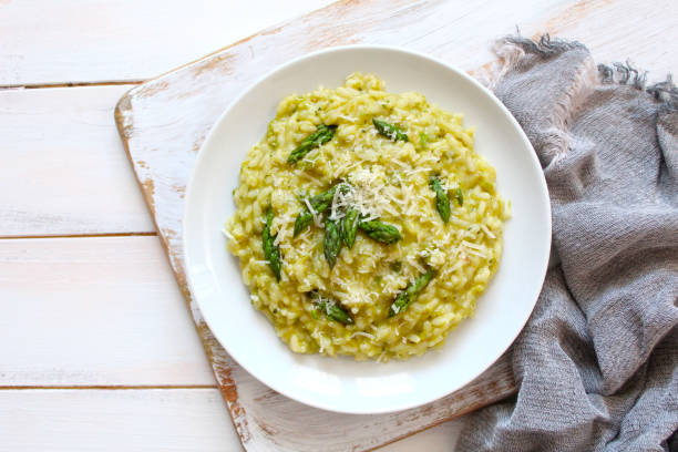 istock Italian risotto with spring asparagus and parmesan cheese on light background. 1193295287