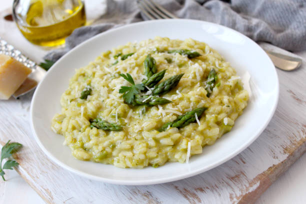 istock Italian risotto with spring asparagus and parmesan cheese on light background. 1193295353