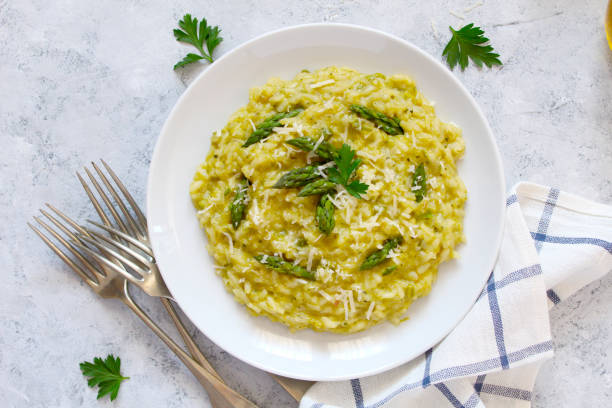 istock Italian risotto with spring asparagus and parmesan cheese on light background. 1193295944