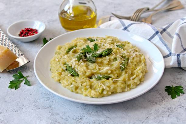 istock Italian risotto with spring asparagus and parmesan cheese on light background. 1193295958