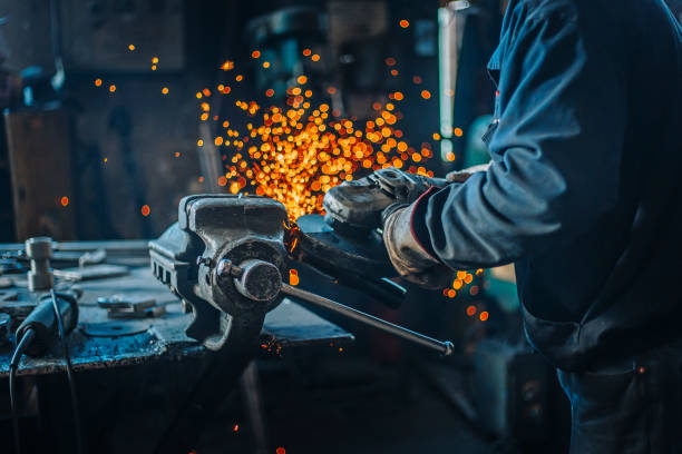 Metal worker use the grinder Industrial metal worker use the grinder in factory metalwork stock pictures, royalty-free photos & images