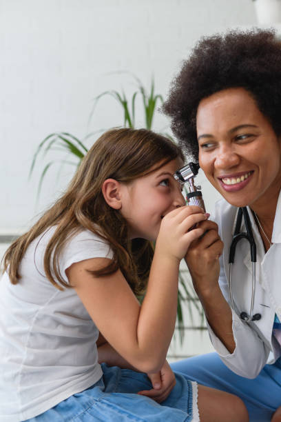 istock Smiling female afro american doctor general practitioner talks and amuses child before medical examination 1193305046