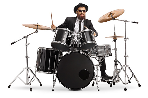 Man in a suit playing drums isolated on white background