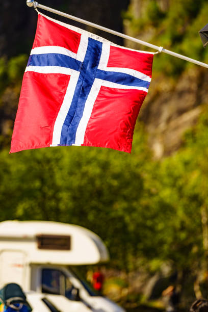 istock Norwegian flag and camper car in mountains 1193307054