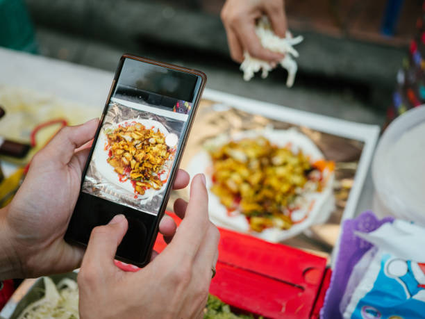 Young man taking selfie with street food Pad Thai in Khao San Road.
