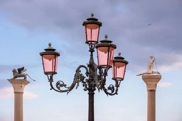 Photo of streetlight, St. Mark's Lion and St. Theodore's statue in the background, Venice, Italy
